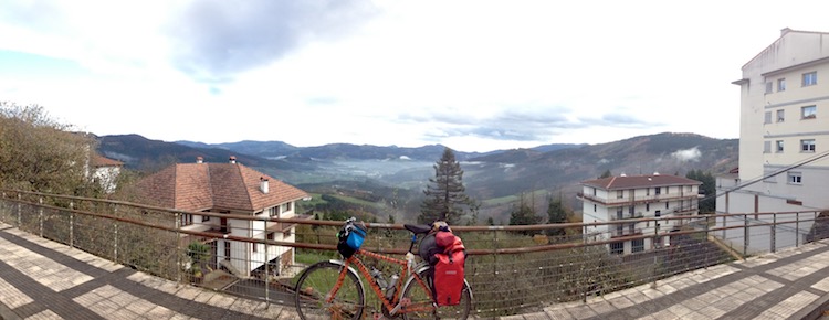 Dans bike propped up against a fence, with mountain peaks in the background (Cantabrian Mountains, Spain)